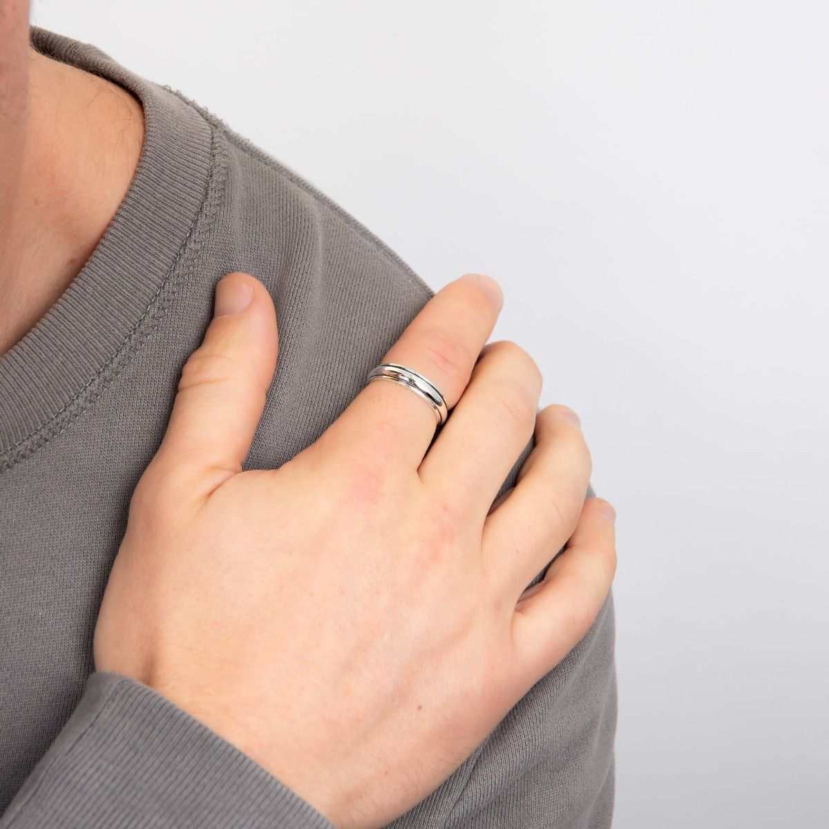 Anello fascia spin uomo in Argento indossato su mano di uomo con maglione grigio di BDG
