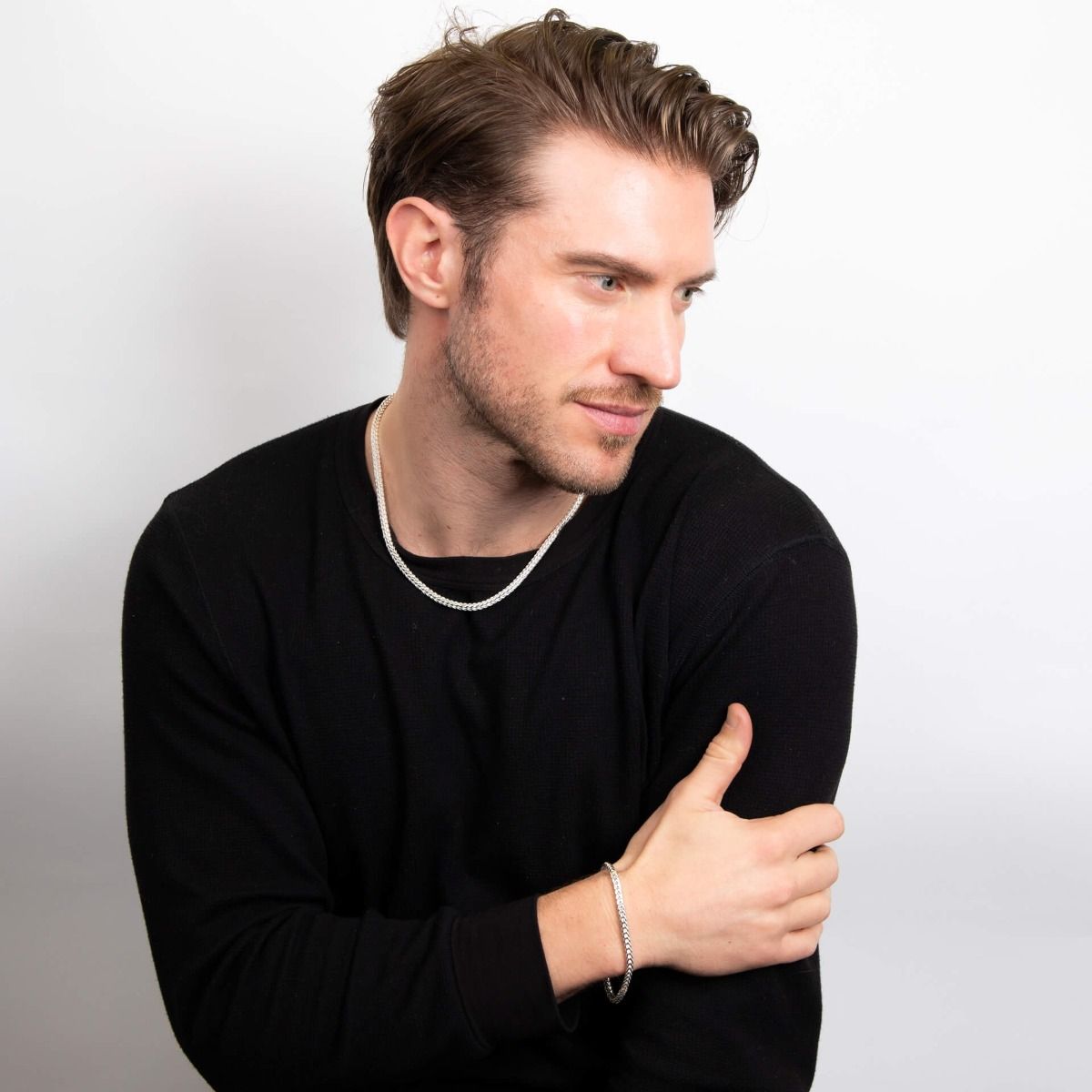 Bracciale argento uomo coda di volpe indossato da uomo con maglione nero, design elegante e moderno