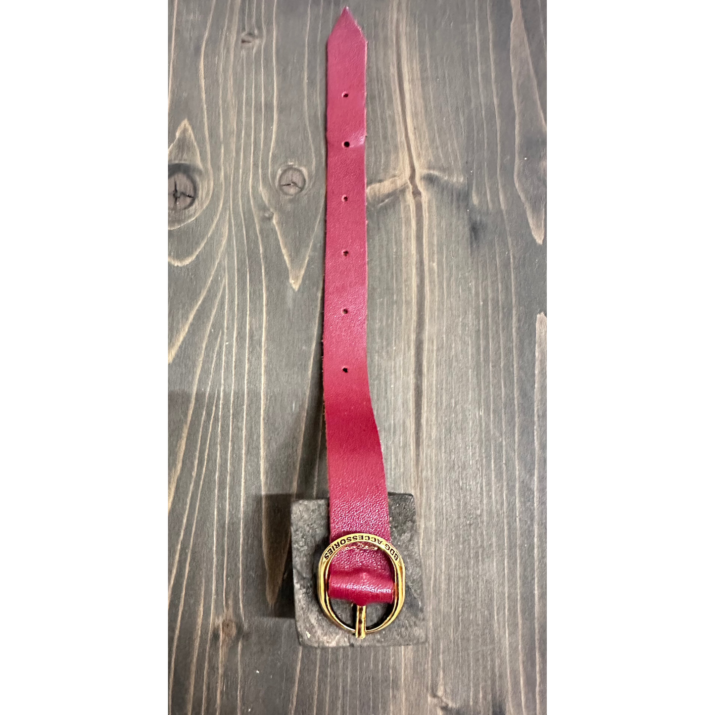 Bracciale ellipse elegante BDG Accessories in pelle rossa con fibbia ovale dorata su sfondo legno