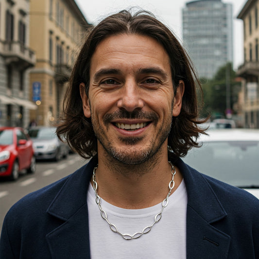 Uomo sorridente indossa collana in argento con catena Marquise in ambiente urbano