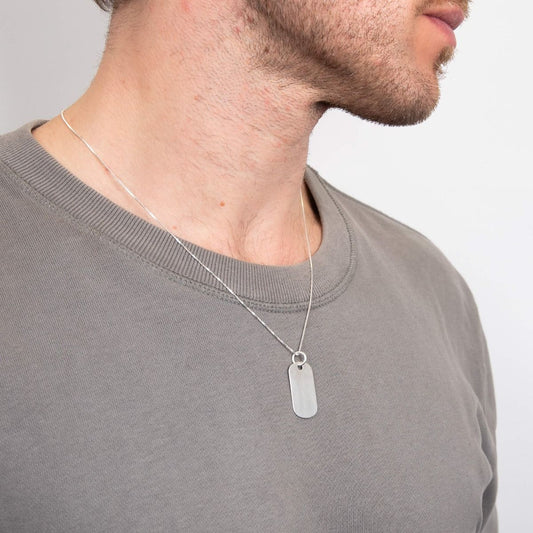 Collana piastrina militare in argento indossata da uomo con maglietta grigia di marca Gecko